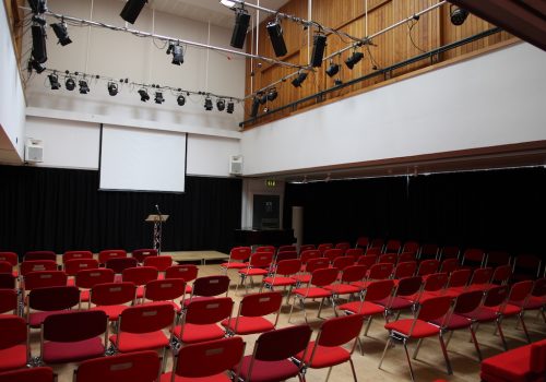 A theatre space with chairs set out facing a projected screen.