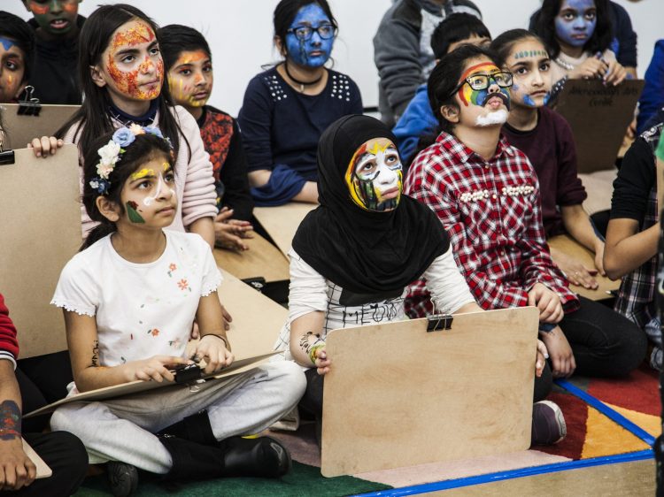 A group of young children with bright painted faces