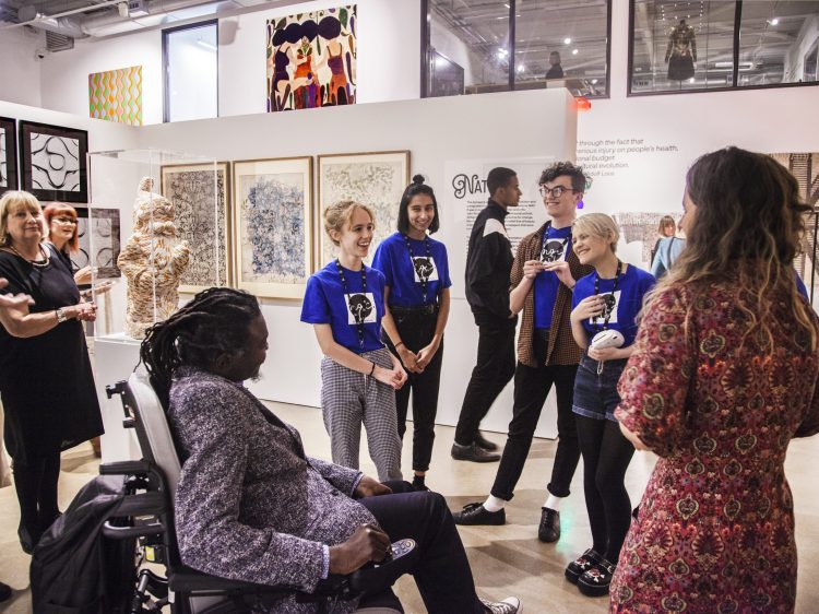 Group of young adult artists talking to an artist