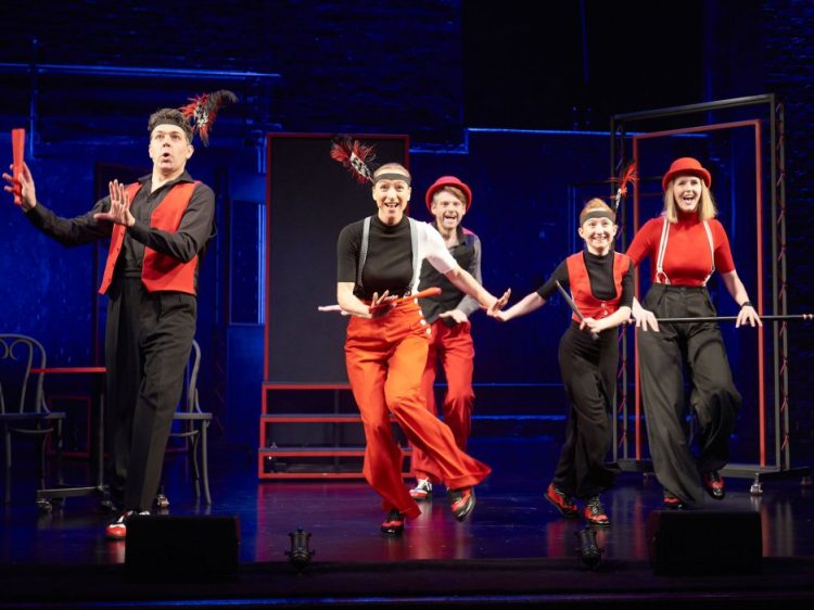 5 people in black and red dancing on stage