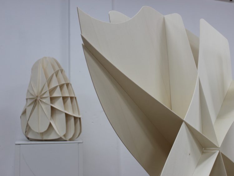 Two contemporary sculptures by Sam Metz in a white room.