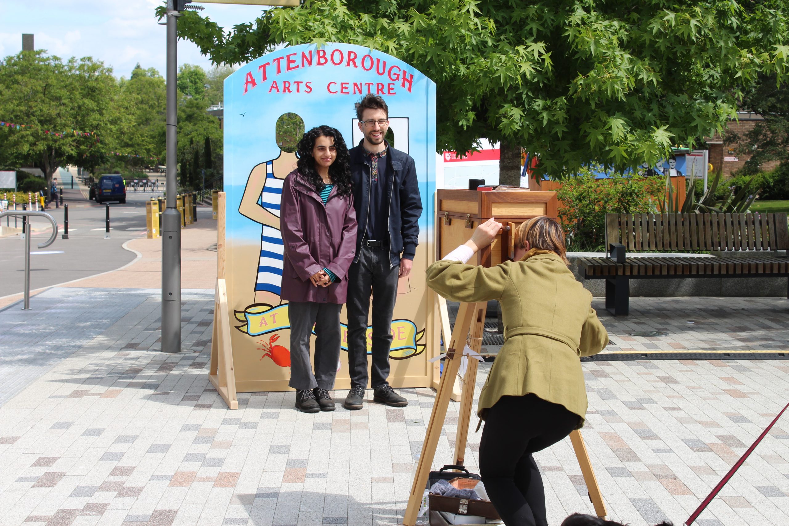 Two people posing in front of our peep-through board being photographed by an Afghan Camera.