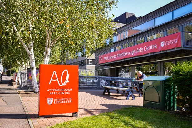 The outside of Attenborough Arts Centre, showing the building and sign, and the picnic benches outside.