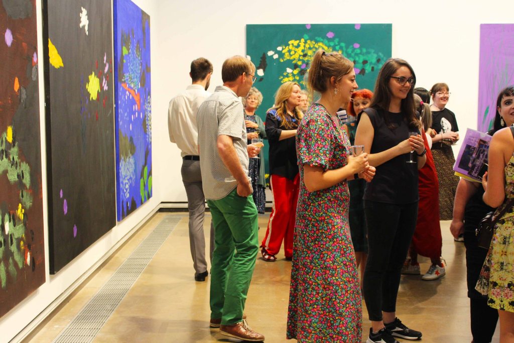 People enjoying themselves, drinking and chatting at the launch of Bruce McLean's Black Garden Paintings exhibition.