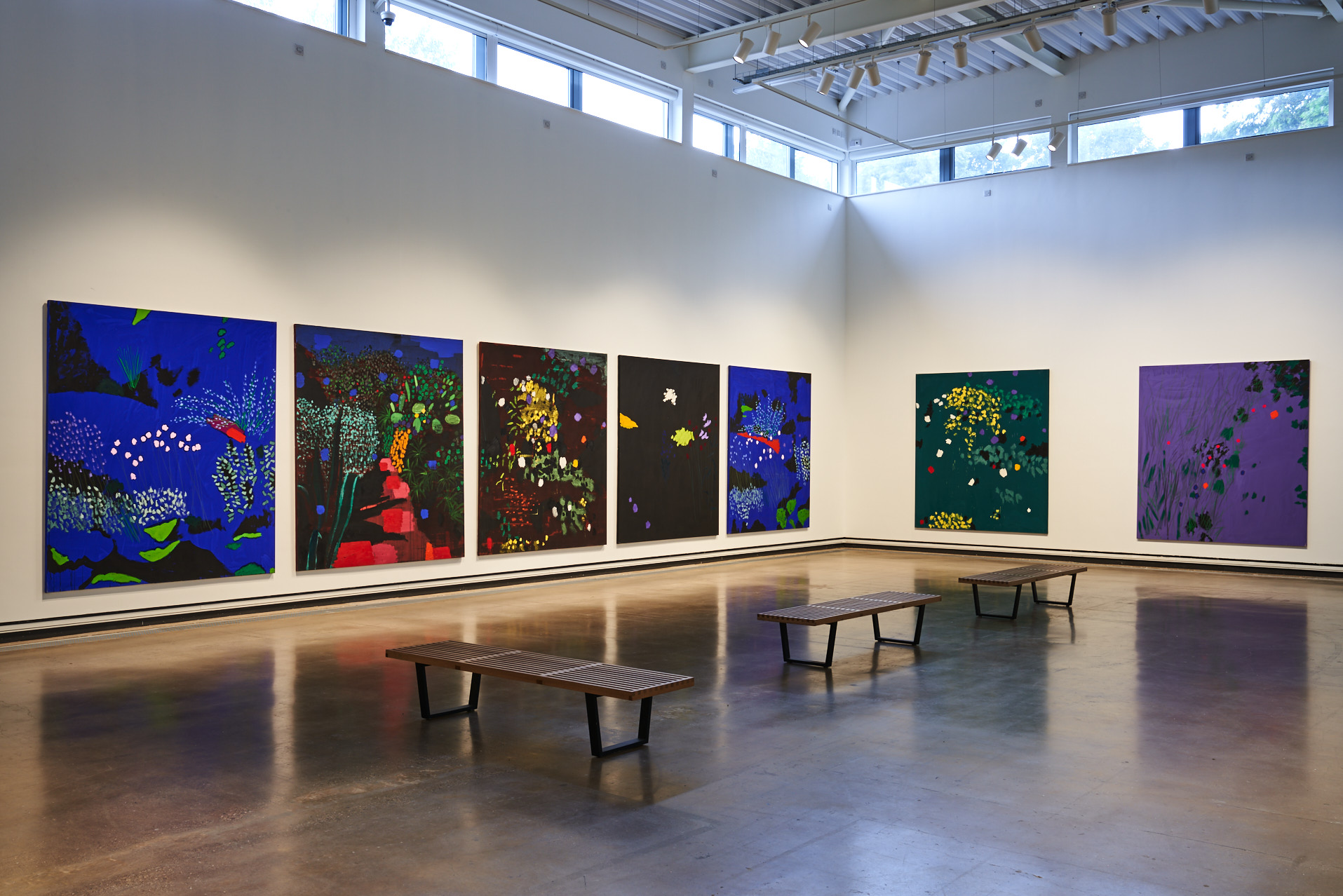 Several large, colourful paintings on the wall of the main gallery.