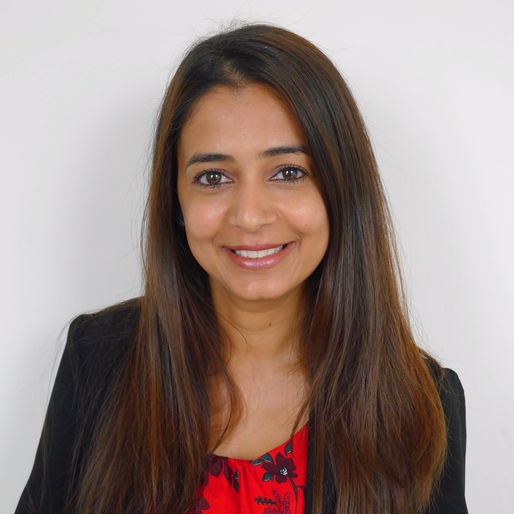 A woman with long brown hair smiling at the camera.