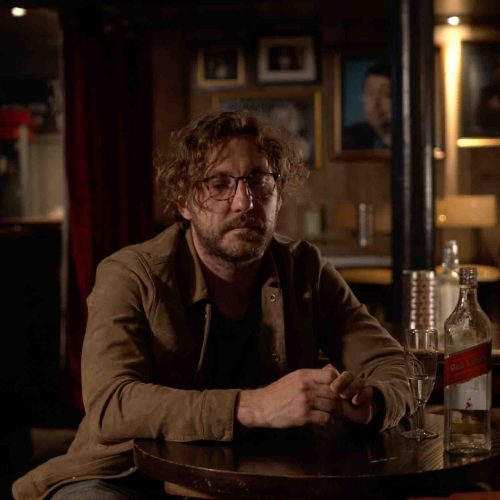 A man sat drinking in a pub.