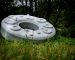 A giant white marble circle with the words 'loop' looping around the top, sat in a green wooded area.