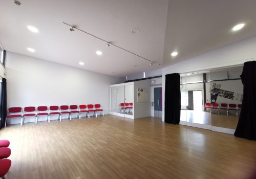 Studio One - an open space with chairs lined up against two walls, and mirrors covering a third.