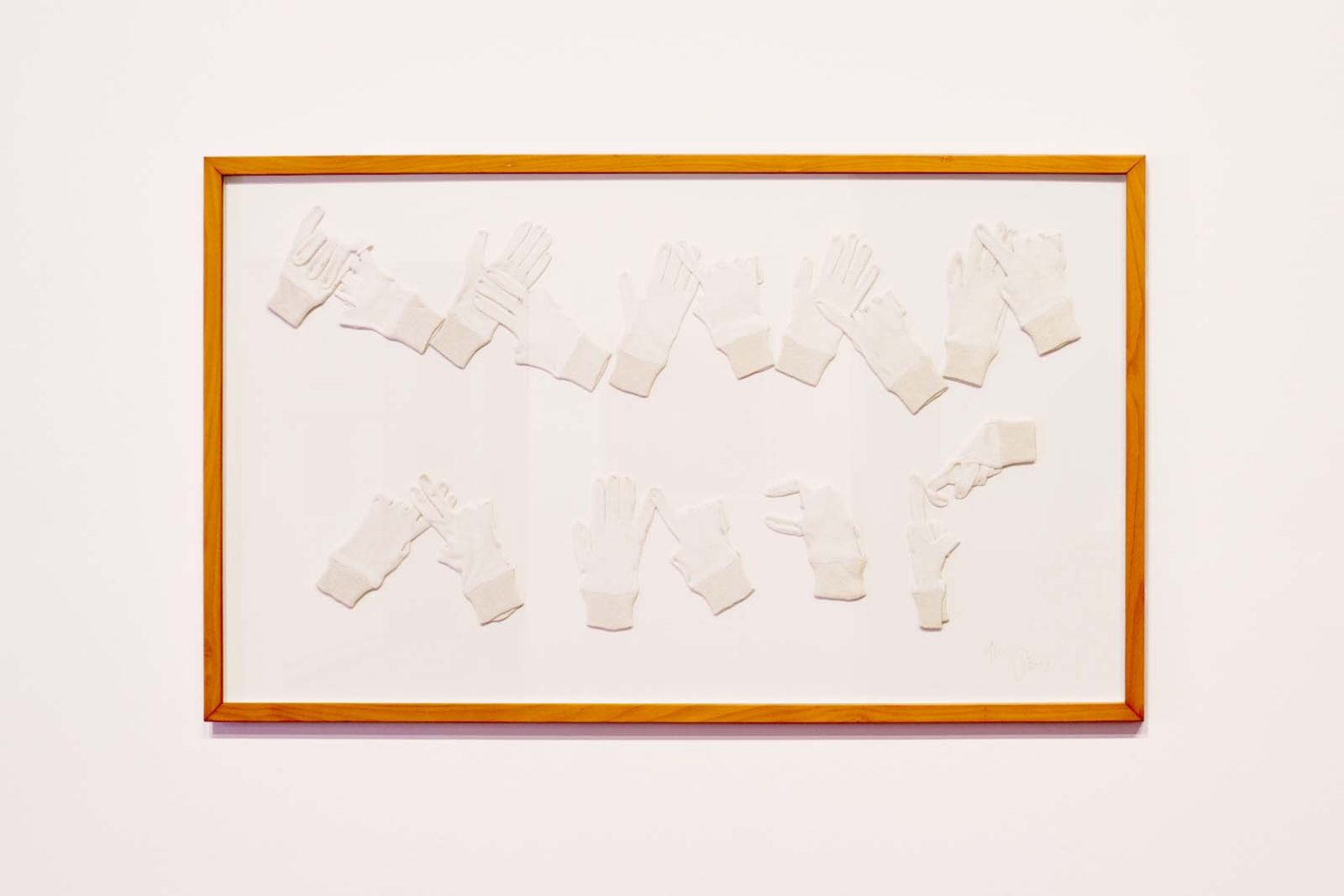A framed white background with white gloves inside spelling something out in BSL.