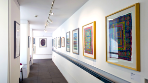 The balcony gallery with a range of paintings from Alan Caine lined along the wall.
