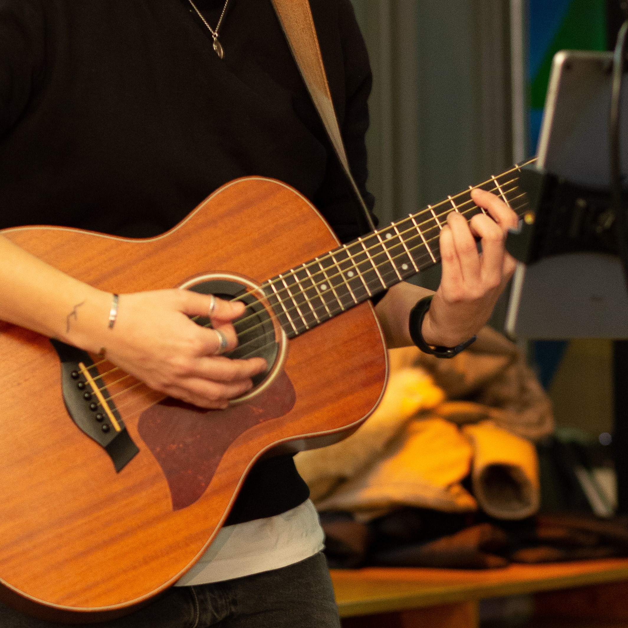 A hand strumming on a acoustic guitar.