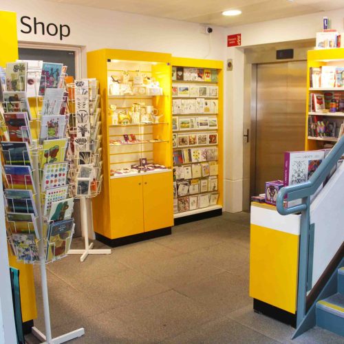 Yellow cupboards displaying cards, trinkets, gift wrapping or other merchandise.