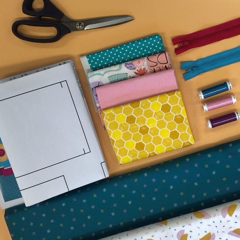 A collection of sewing fabrics and materials displayed on a table.