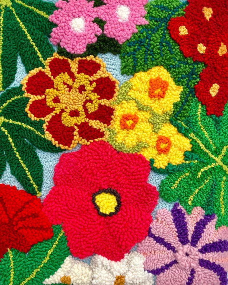 A bright and colourful punch needle scene of a mix of different flowers.