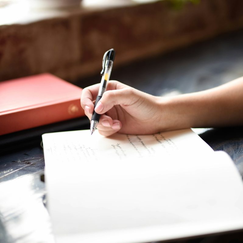 A hand writing into a book.