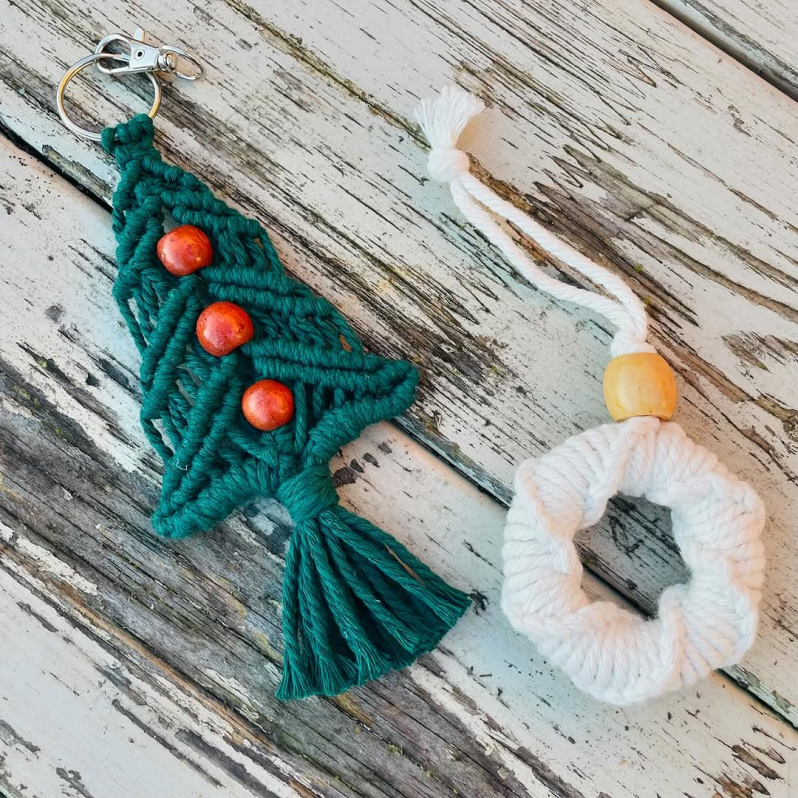 A couple of Christmas macramé decorations placed on a wooden surface