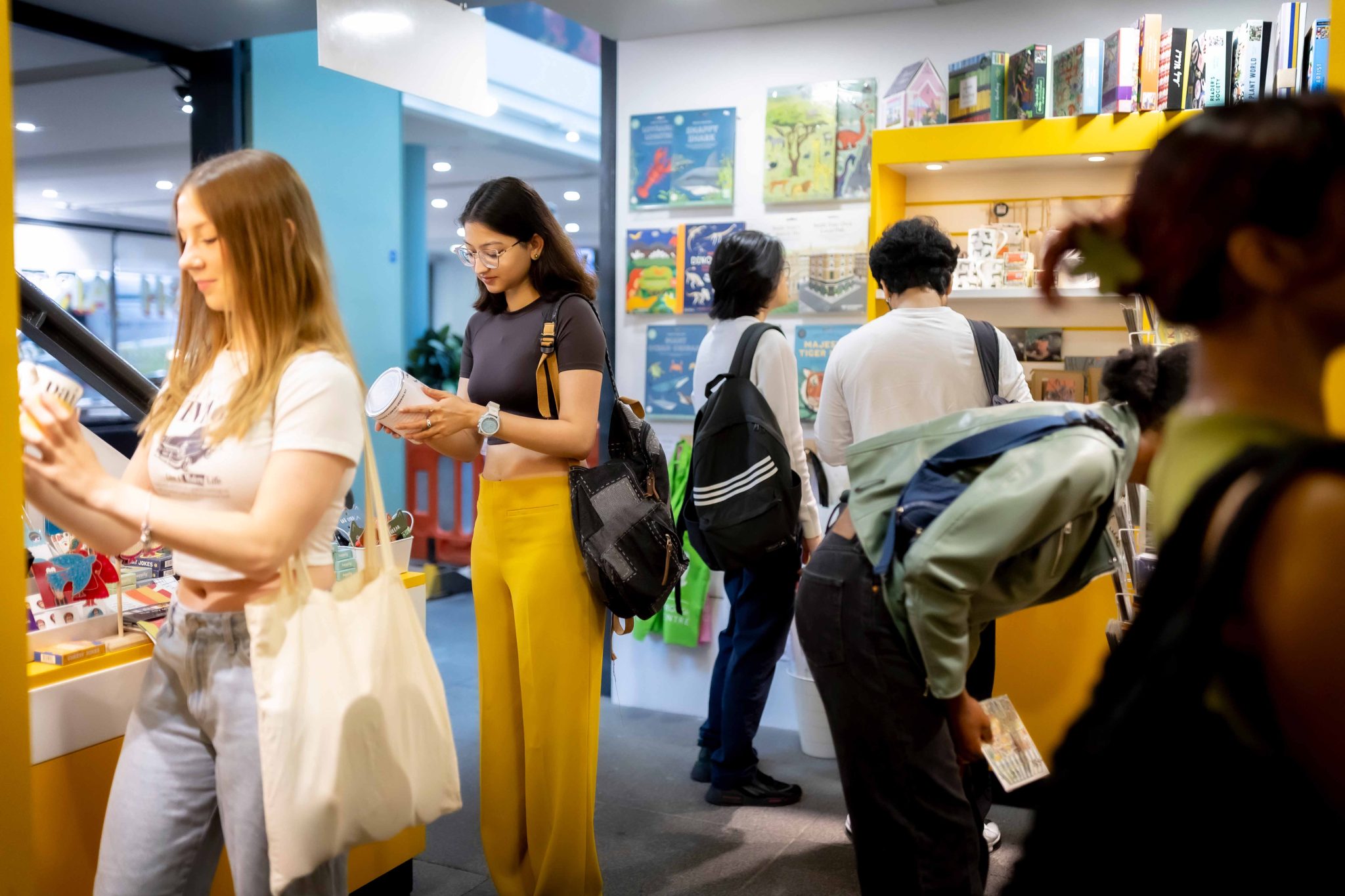 A group of young people in a shop looking at items.