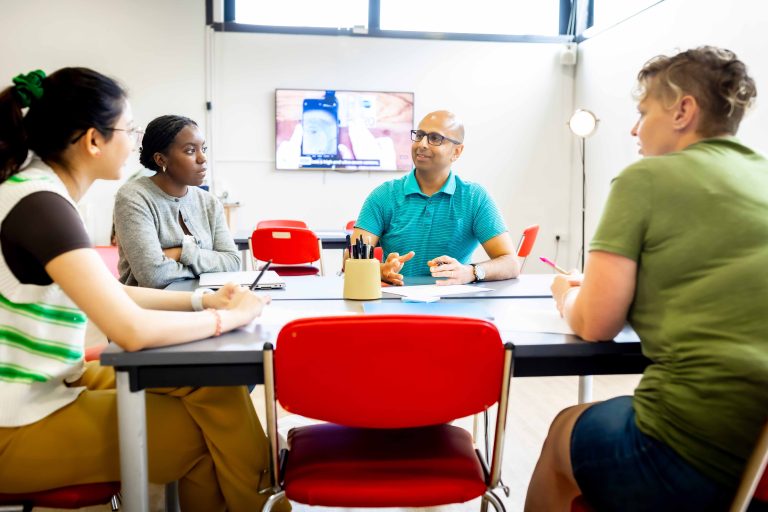 A table with four people sat around discussing topics.