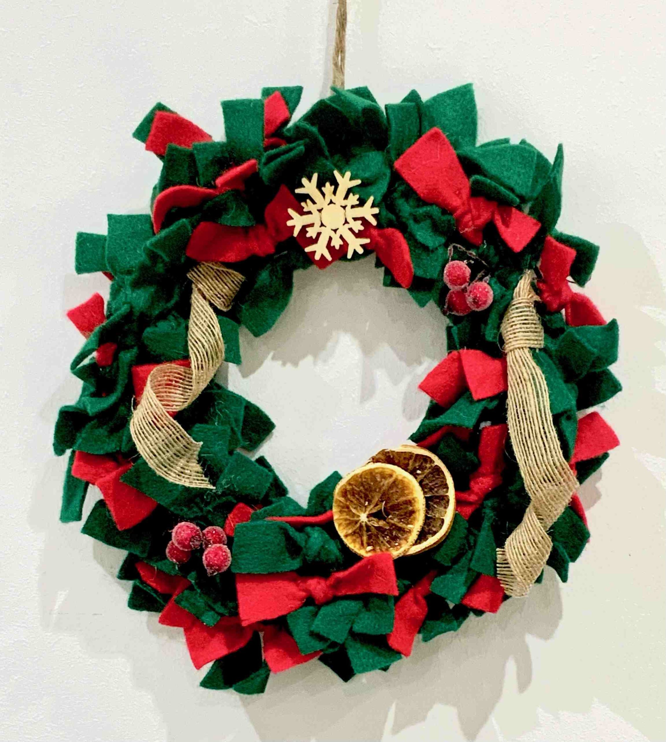 A wreath made felt stripes, with dried fruit.