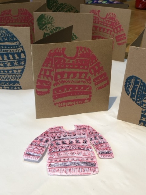 A lino cut-out off a Christmas jumper, which has been pressed onto many different cards with different coloured inks.