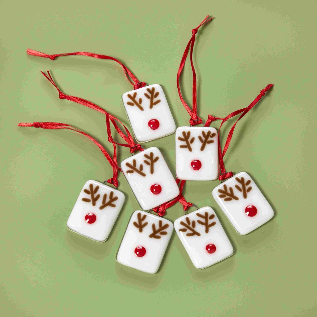 White glass tiles with brown antlers and red noses.