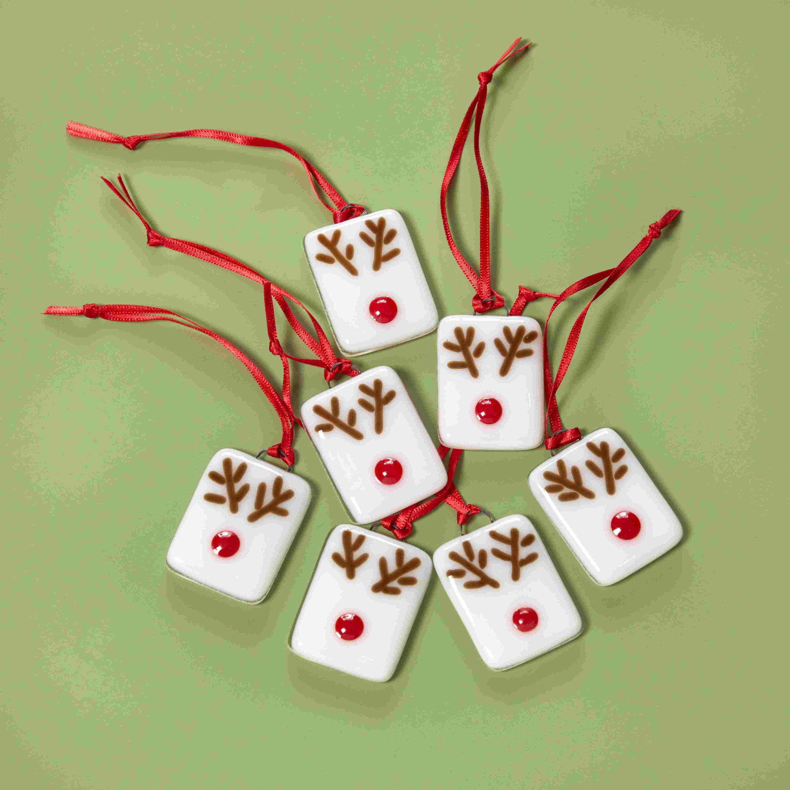 White glass tiles with brown antlers and red noses.