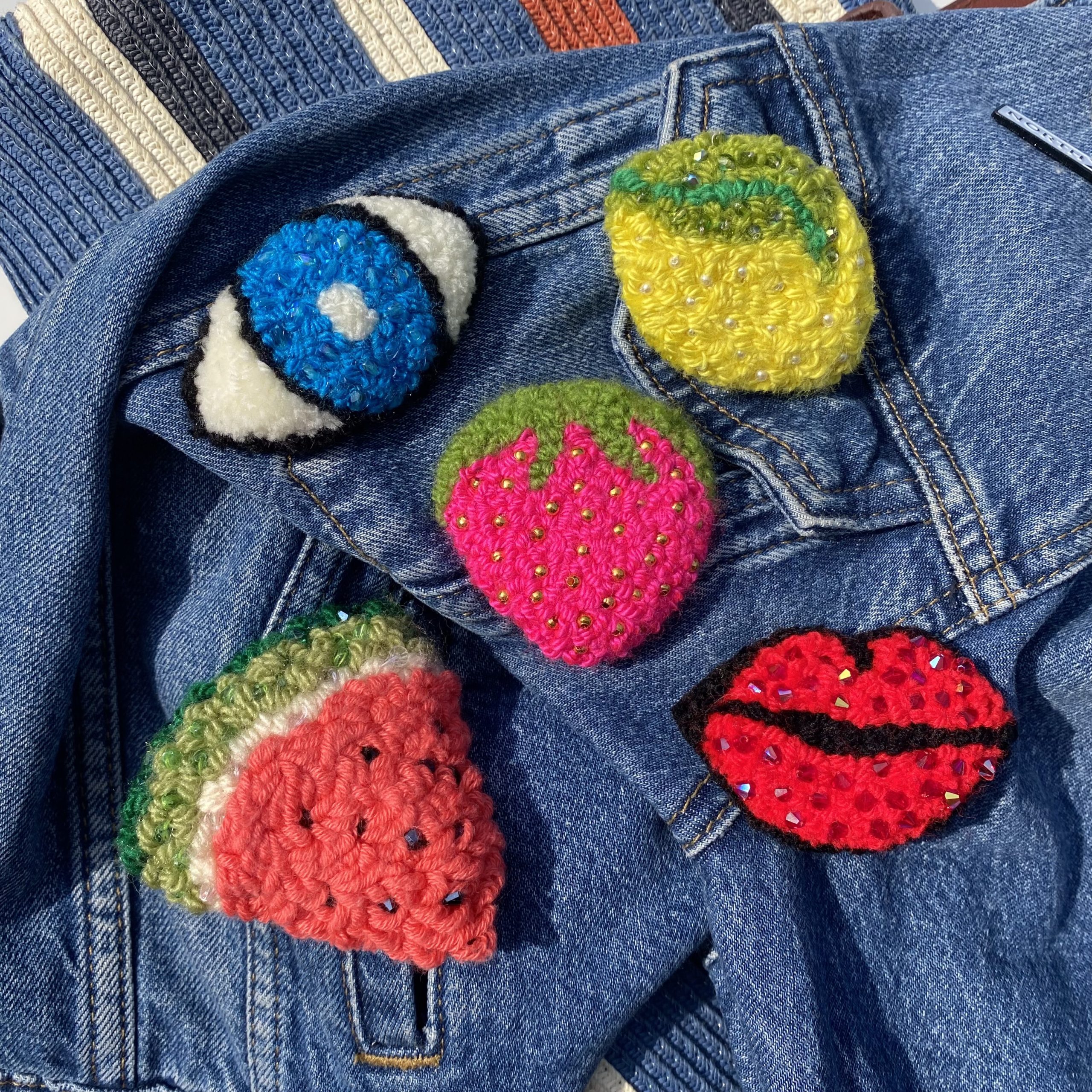 A range of fibre badges including a watermelon, lips, and an eye.