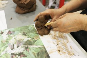 Two hand sculpting clay.