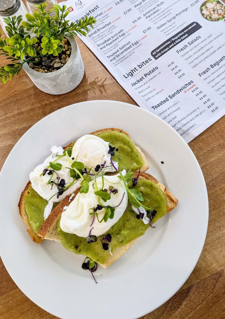 Avocado on toast with cheese, on a plate on a wooden table.