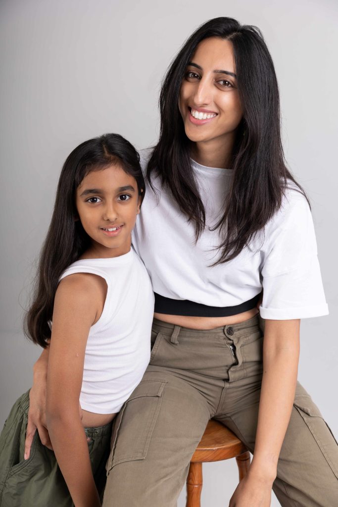 A young girl and woman smiling together.