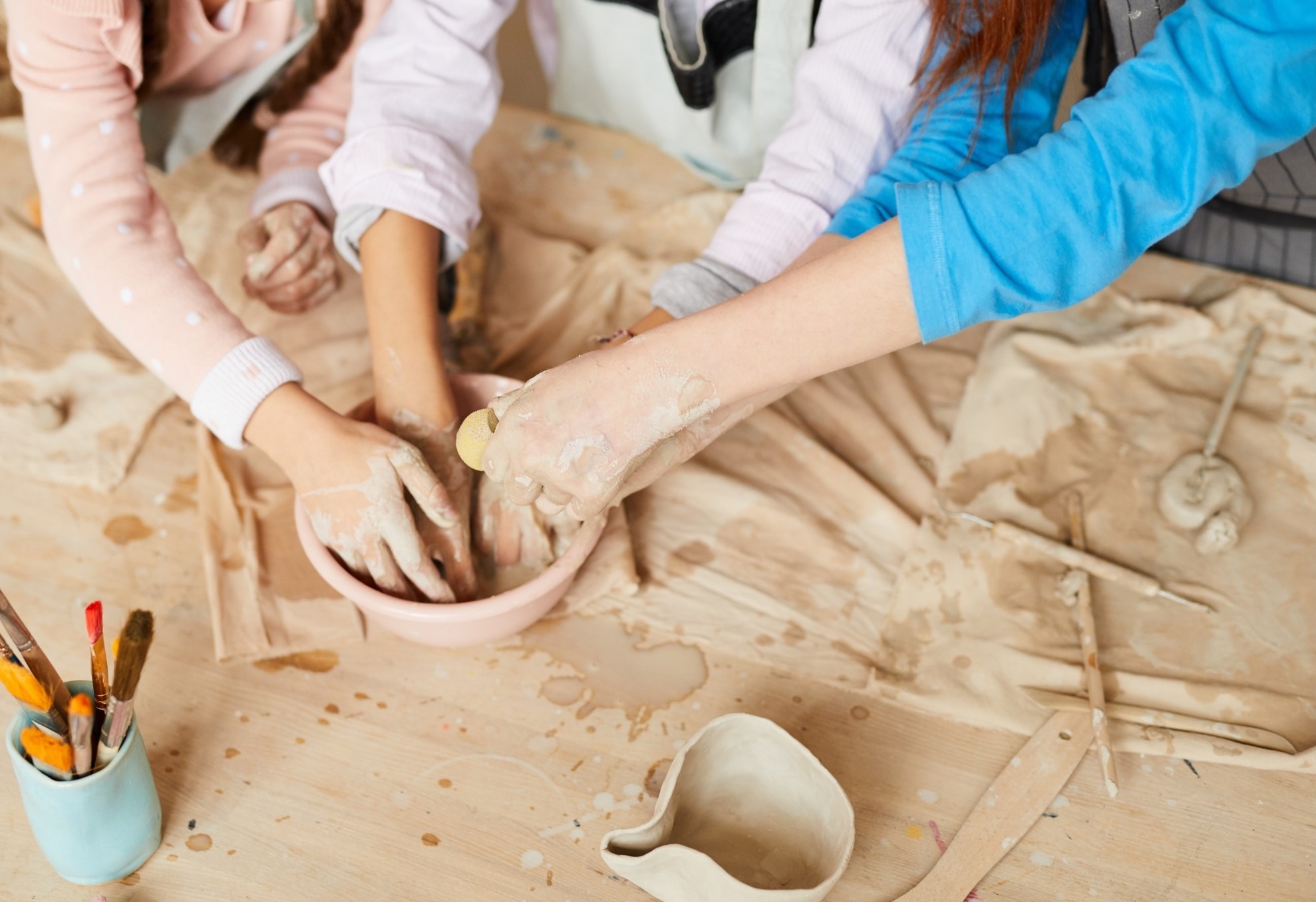 Two handles creating a pottery bowl together.