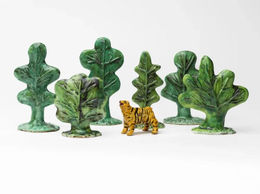 A scene of ceramic trees and a tiger on a white background.