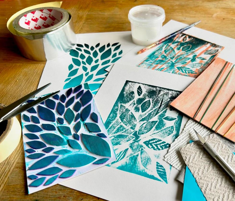 A series of lino prints on paper, using blue and teal paints.