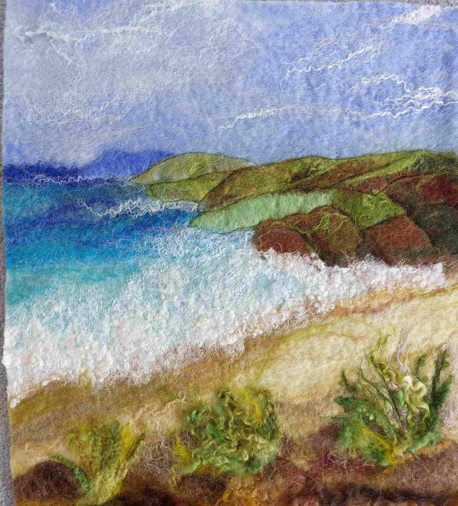 A beach and hill scene made out of felted fabrics.