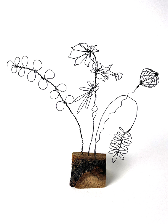 Wild flowers made from wire mounted onto a small wooden cube.