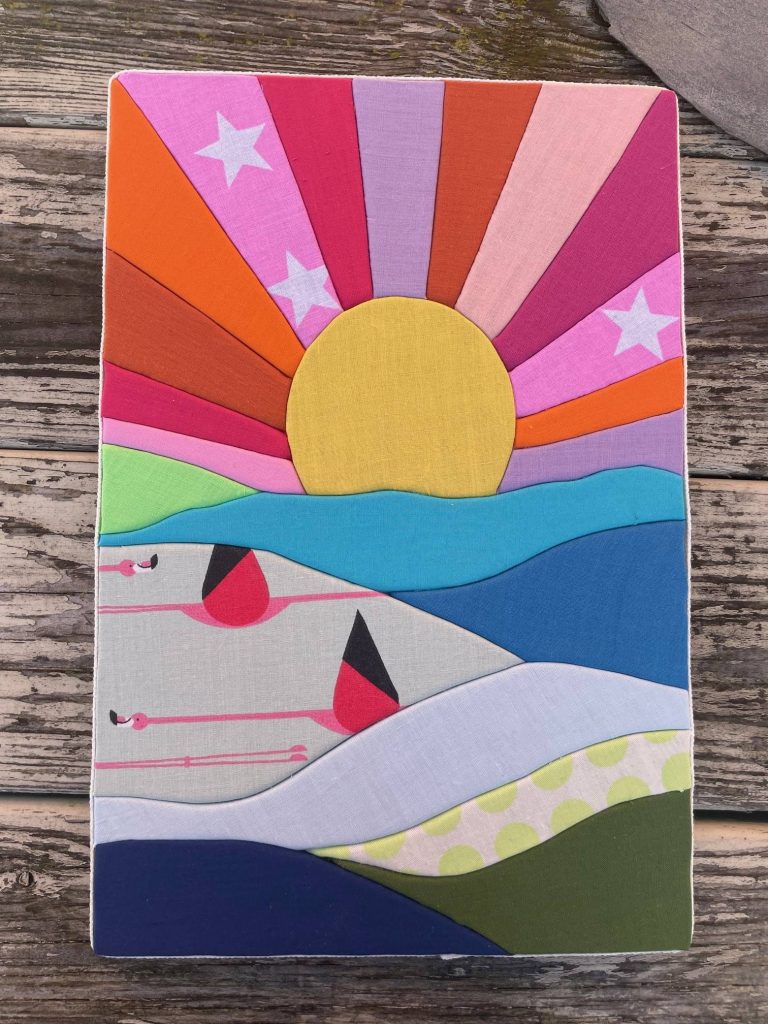 A colourful sunset and beach made out of fabric strips.