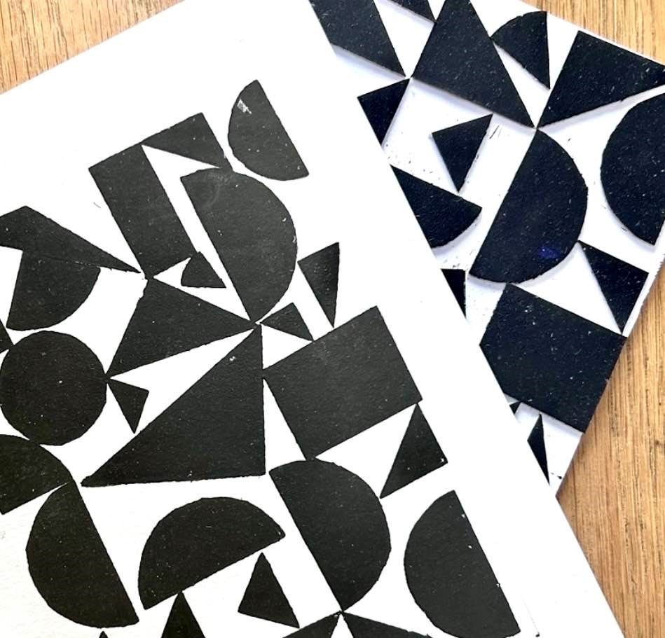 Black geometric print of random shapes on a white piece of paper.