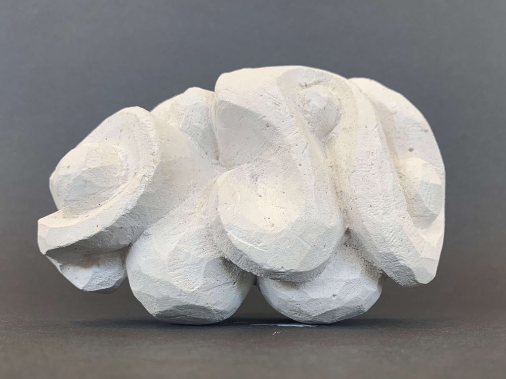 White plaster sculpture in an organic swirl shape.